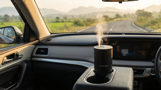 Portable aroma diffuser for car placed in cup holder with morning light and scenic road