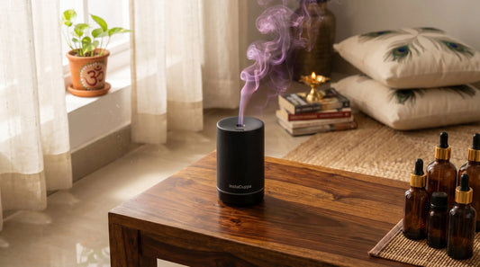 Aroma oil diffuser on a wooden console in a modern Indian living room with soft purple mist rising, essential oil bottles nearby, warm natural light