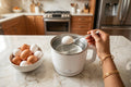 Indian woman placing egg into multicook electric kettle - can you boil eggs in electric kettle