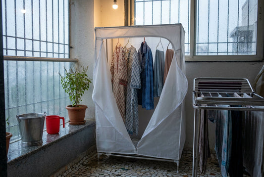 Portable cloth dryer machine drying clothes indoors during heavy monsoon rain in an Indian home