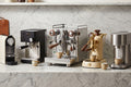 Multiple espresso machines arranged in lineup for comparison roundup on marble counter