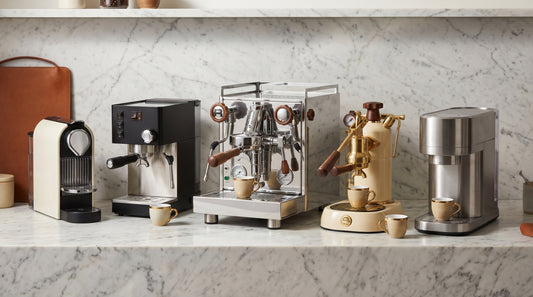 Multiple espresso machines arranged in lineup for comparison roundup on marble counter
