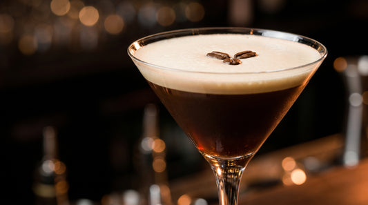 Espresso martini cocktail in a classic martini glass with three coffee beans on creamy foam