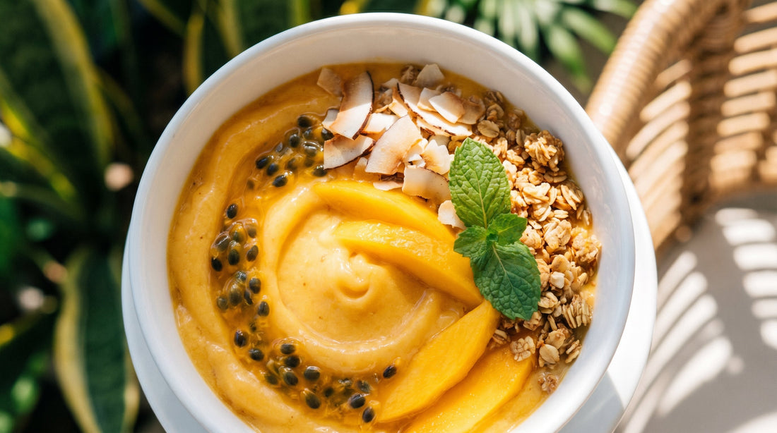 Bright yellow mango smoothie bowl with fresh mango slices chia seeds and coconut on Indian kitchen counter