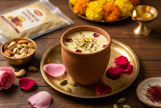 Thandai recipe served in a clay kulhad with saffron, rose petals, almonds, and pistachios in a festive Indian setting