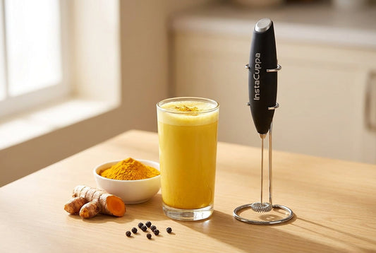 Turmeric milk side effects — a glass of haldi doodh with turmeric root, powder and the InstaCuppa Milk Frother