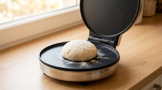 Open electric roti maker with a soft dough ball on the non-stick plate