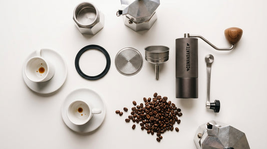 Moka pot accessories flat lay: gasket, filter, funnel, grinder, cups, coffee beans