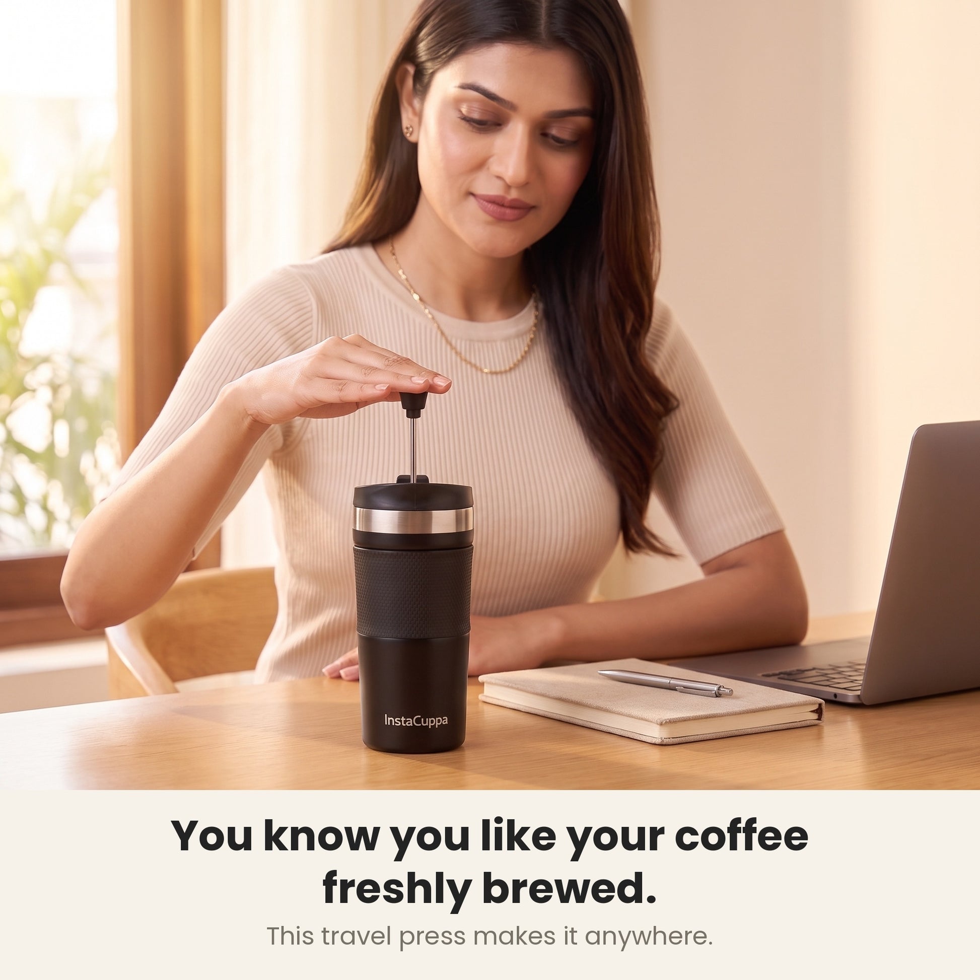 Woman enjoying freshly brewed coffee from her InstaCuppa French Press Travel Mug by a bright window