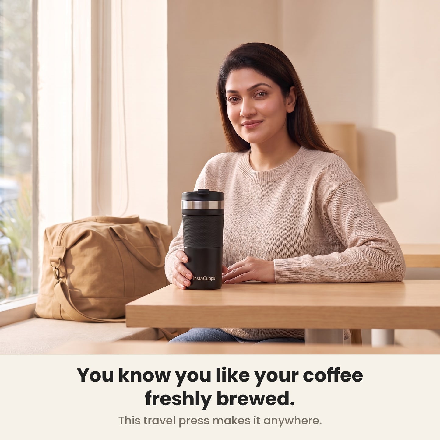 Woman enjoying freshly brewed coffee from her InstaCuppa French Press Travel Mug by a bright window