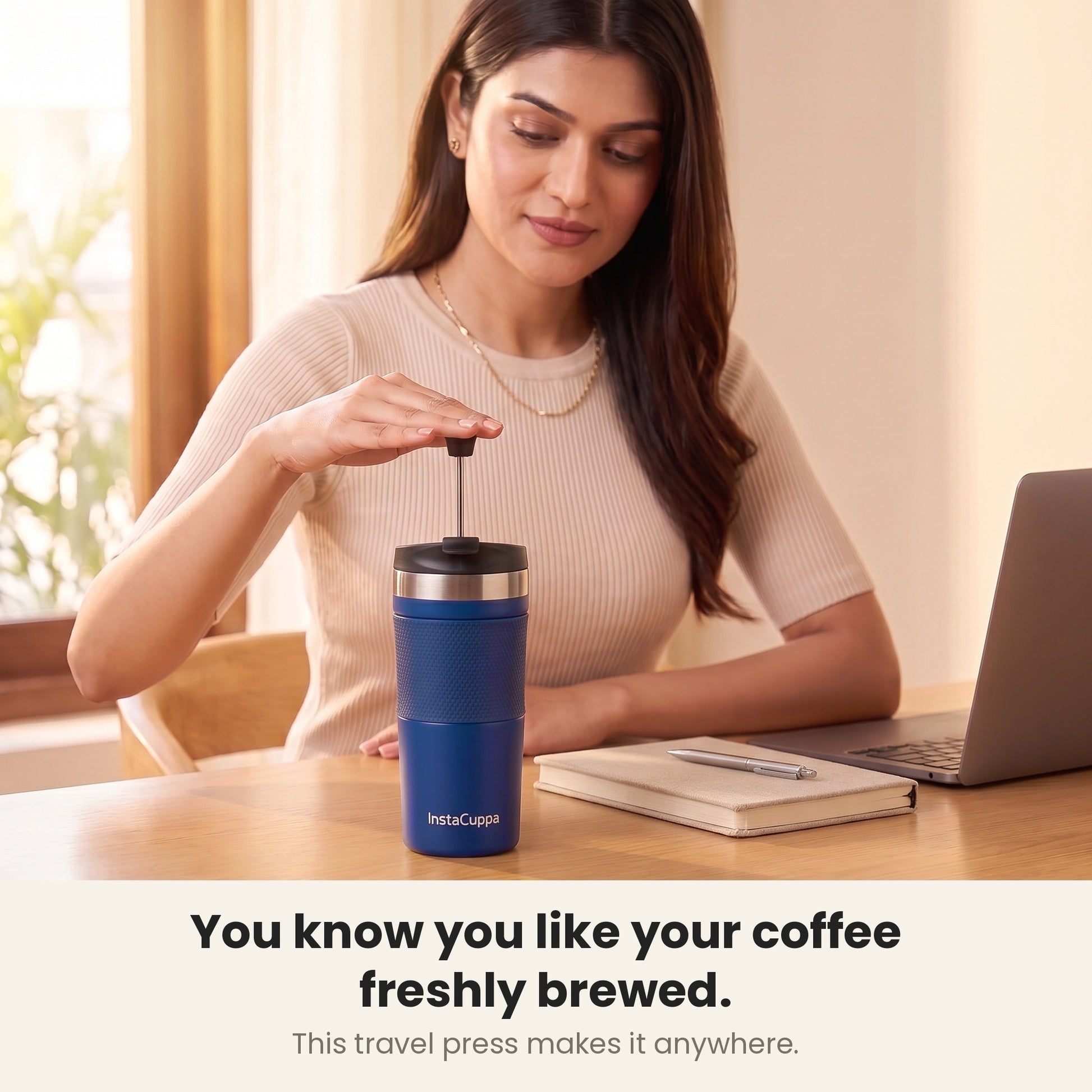 Woman enjoying freshly brewed coffee from her navy blue InstaCuppa French Press Travel Mug at her desk