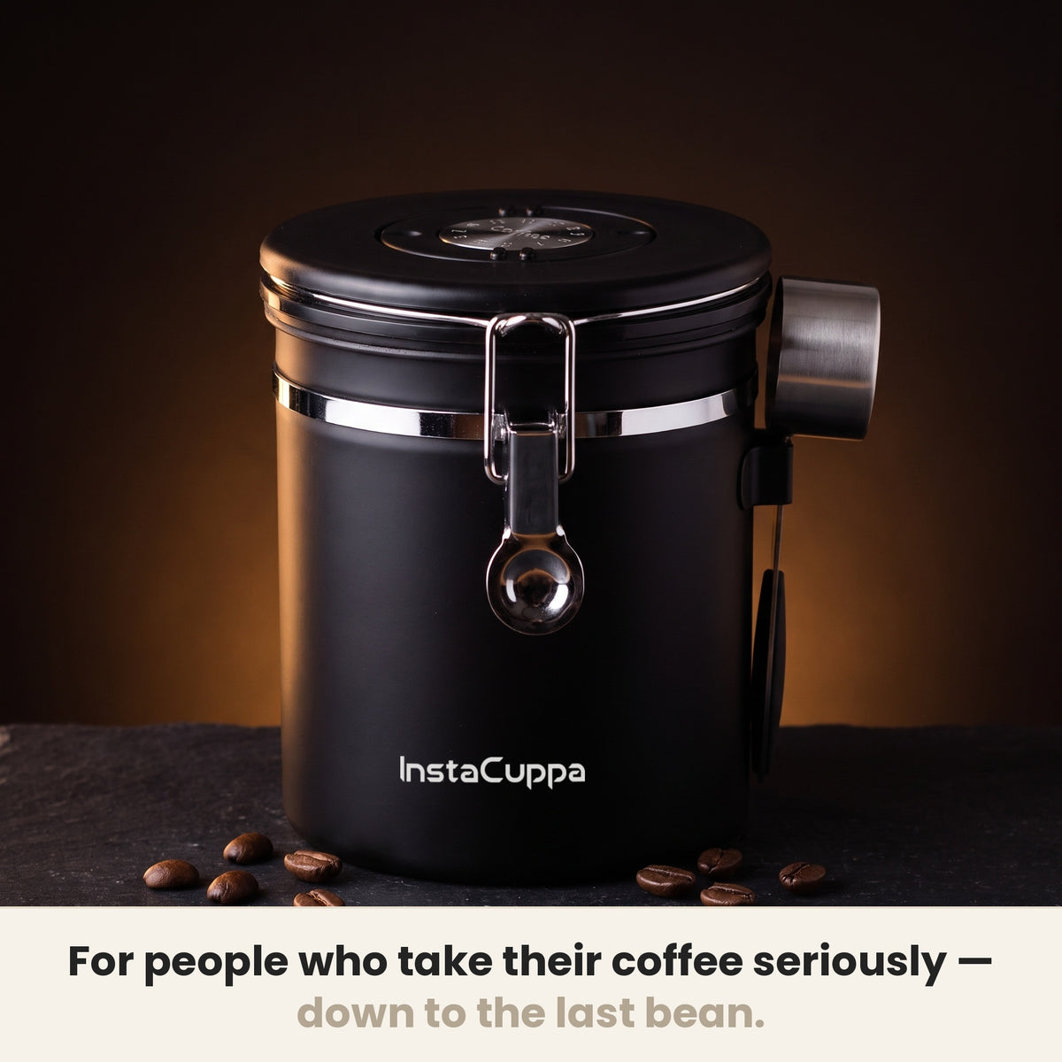 InstaCuppa Airtight Coffee Container 500g - Black - on a dark kitchen counter with whole coffee beans