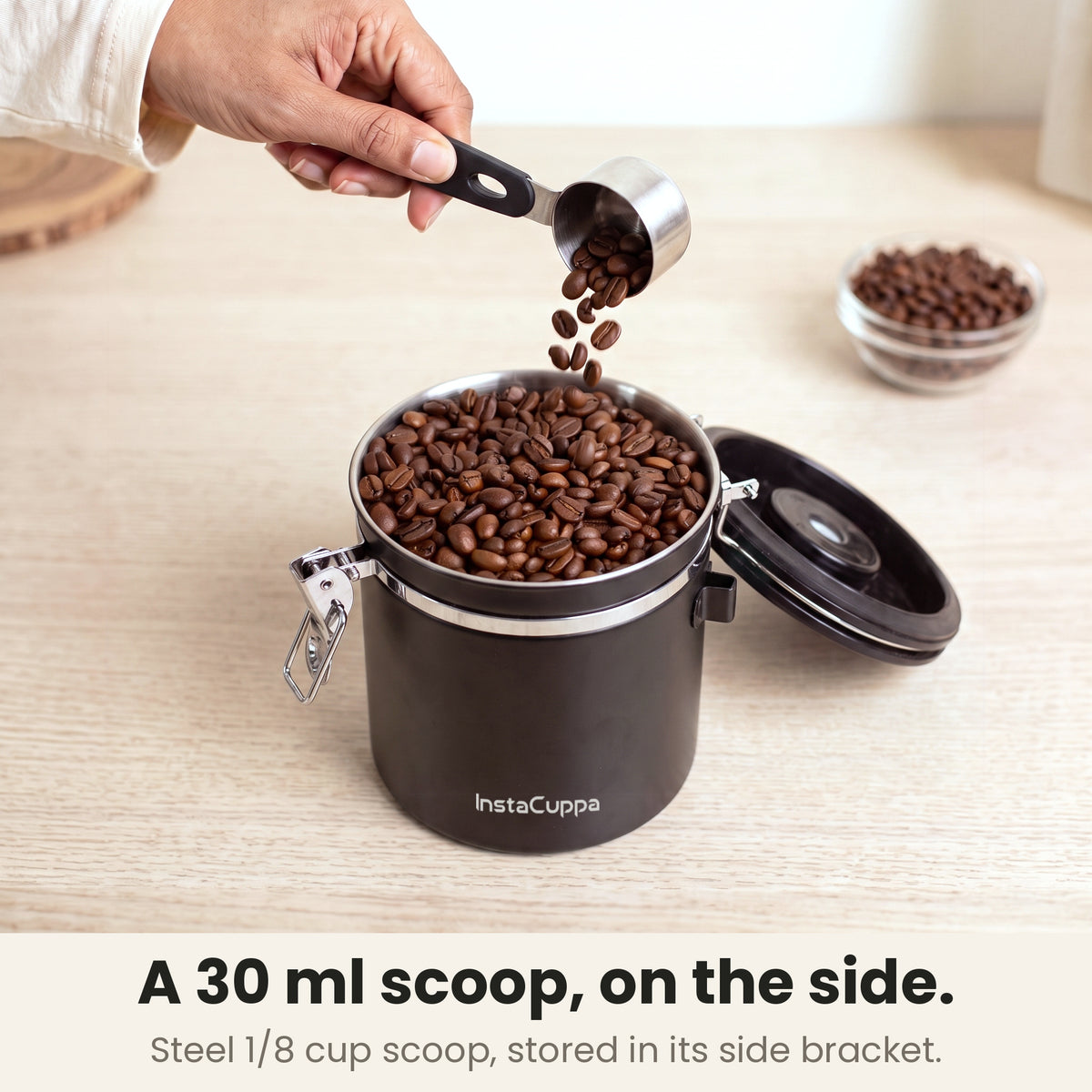 Airtight coffee container - Black - 1/8 cup 30 ml stainless steel scoop pouring coffee beans into the canister, stored in its side bracket