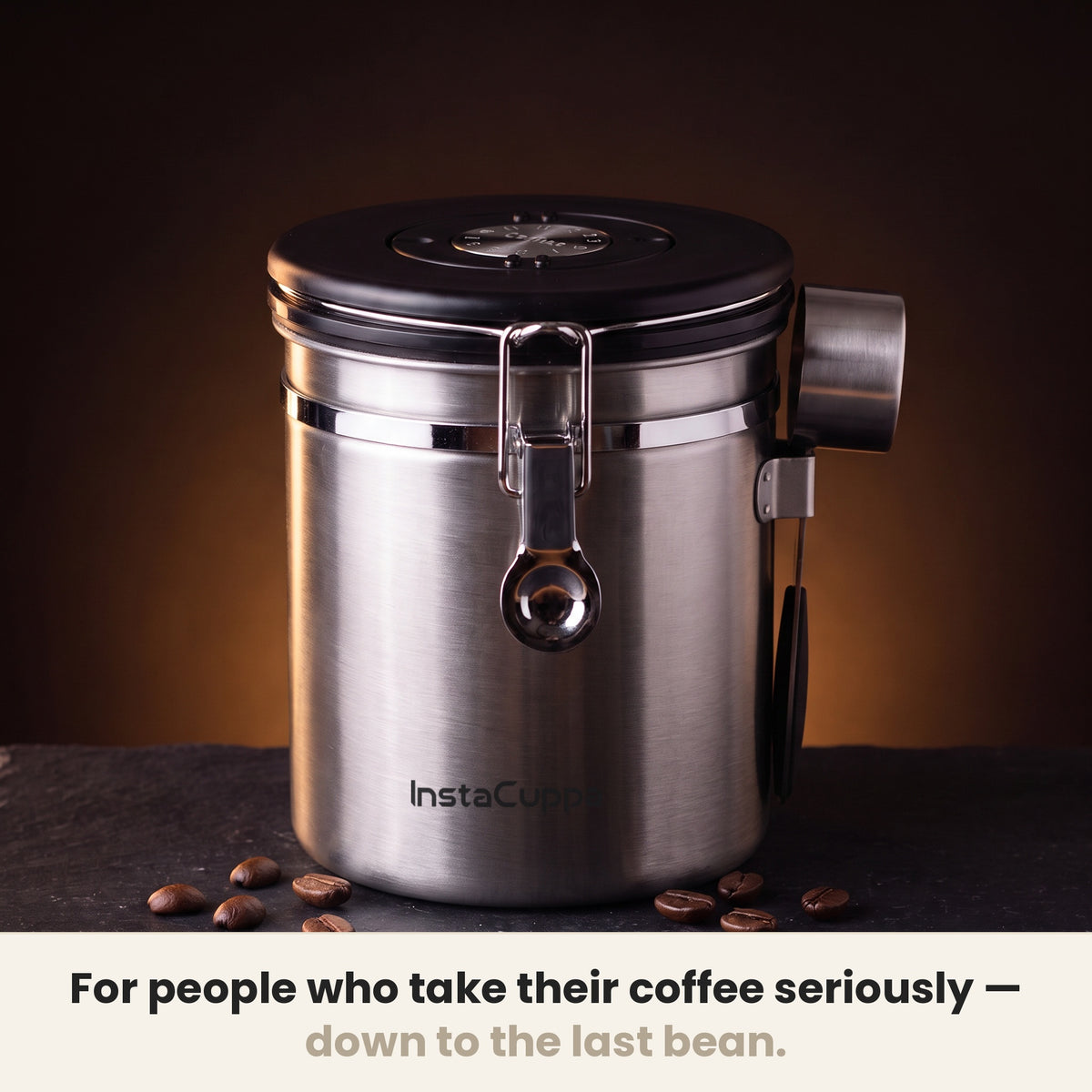InstaCuppa Airtight Coffee Container 500g - Steel - on a dark kitchen counter with whole coffee beans