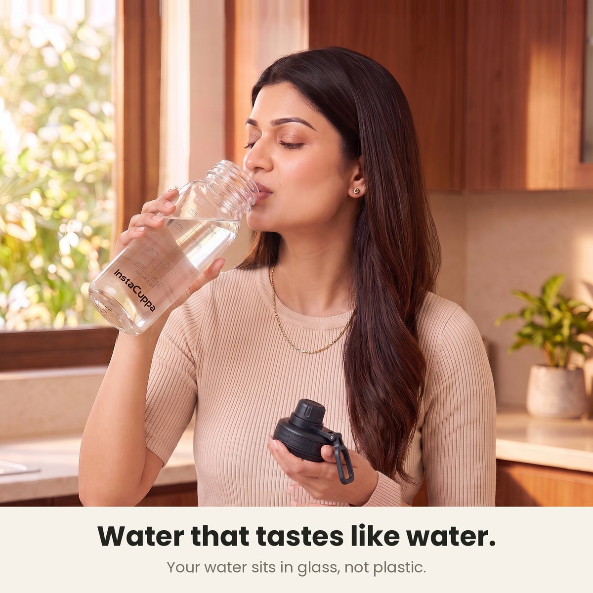 InstaCuppa Borosilicate Glass Water Bottle 1 Litre - Black - water that tastes like water: drinking straight from the glass mouth, lid in her other hand