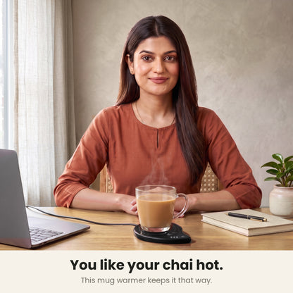 InstaCuppa coffee mug warmer for desk — woman at her home office desk with a glass cup of chai kept hot by the cup warmer