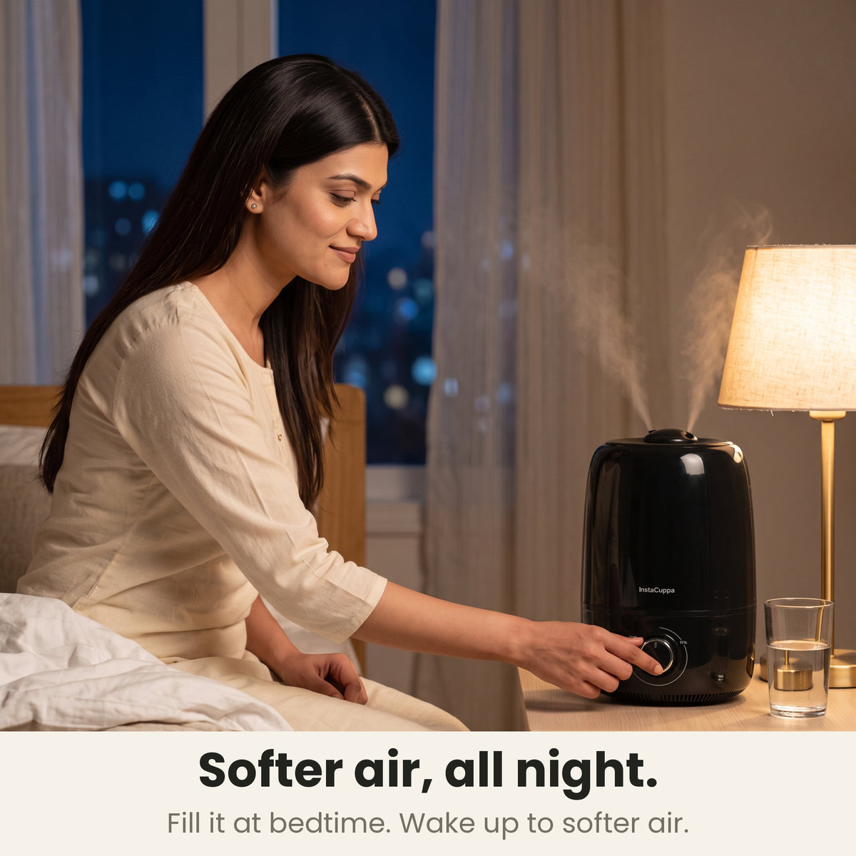 Cool mist humidifier for bedroom: woman turning the mist dial at bedtime as the InstaCuppa 4 L humidifier mists on the bedside table, softer air all night