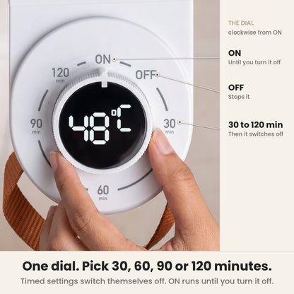 Shoe dryer machine dial close-up: a hand turns the knob with its 48 °C display; ON runs until you turn it off, OFF stops it, and 30, 60, 90 or 120 min switch it off when the time is up