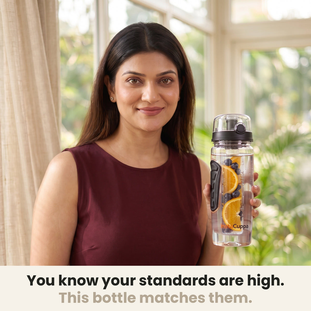 InstaCuppa Fruit Infuser Water Bottle 1 Litre - Black - woman holding the bottle in a sunlit room, made for your standards