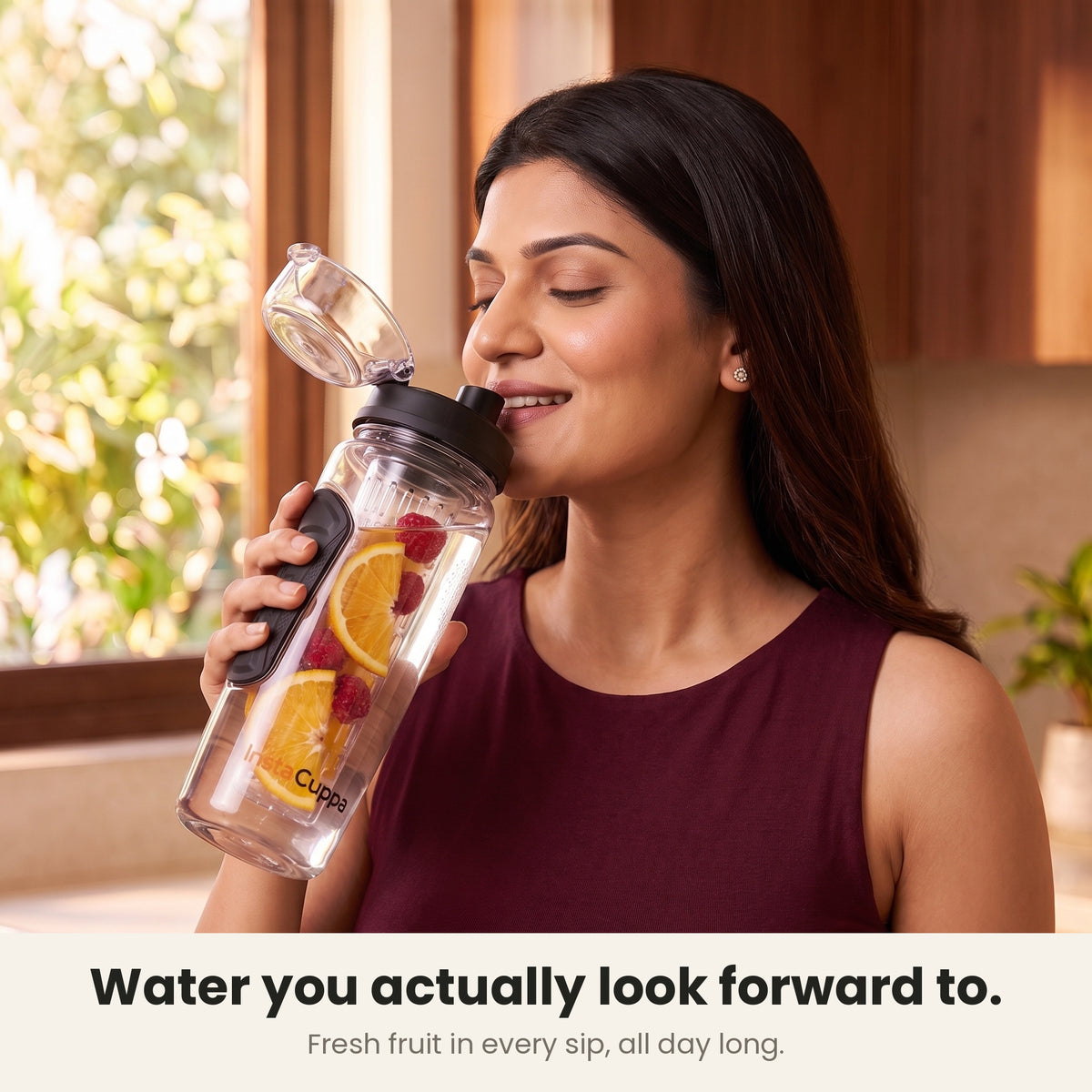 InstaCuppa Fruit Infuser Water Bottle 1 Litre - Black - woman sipping fruit-infused water from the flip-top lid