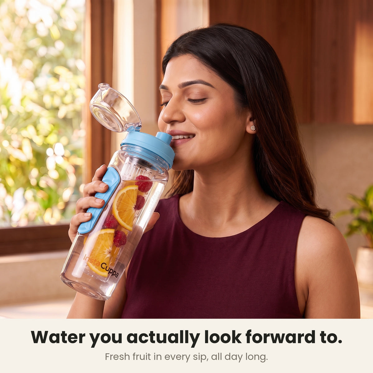 InstaCuppa Fruit Infuser Water Bottle 1 Litre - Blue - woman sipping fruit-infused water from the flip-top lid