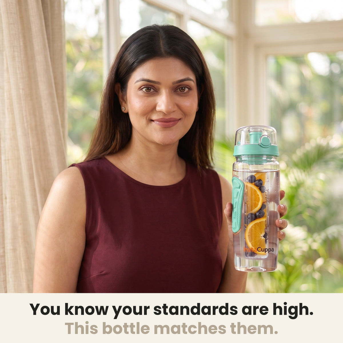 InstaCuppa Fruit Infuser Water Bottle 1 Litre - Green - woman holding the bottle in a sunlit room, made for your standards