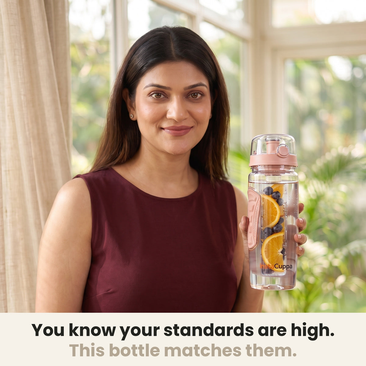 InstaCuppa Fruit Infuser Water Bottle 1 Litre - Rose - woman holding the bottle in a sunlit room, made for your standards