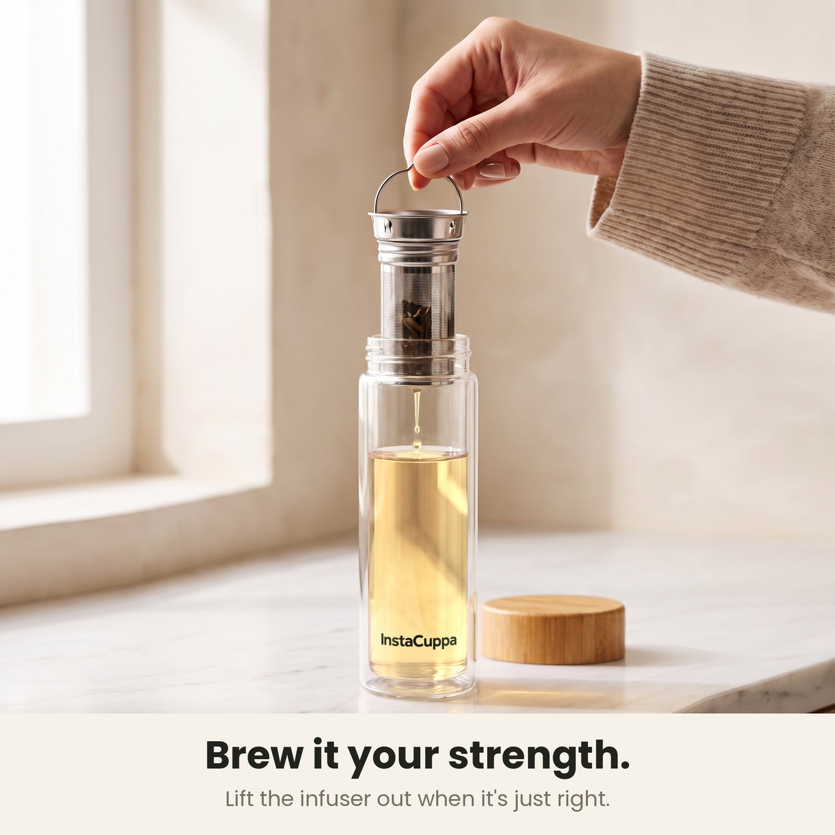 InstaCuppa Glass Tea Infuser Bottle 450 ML - brew it your strength: lifting the 2-in-1 steel infuser out by its wire handle when the tea is just right