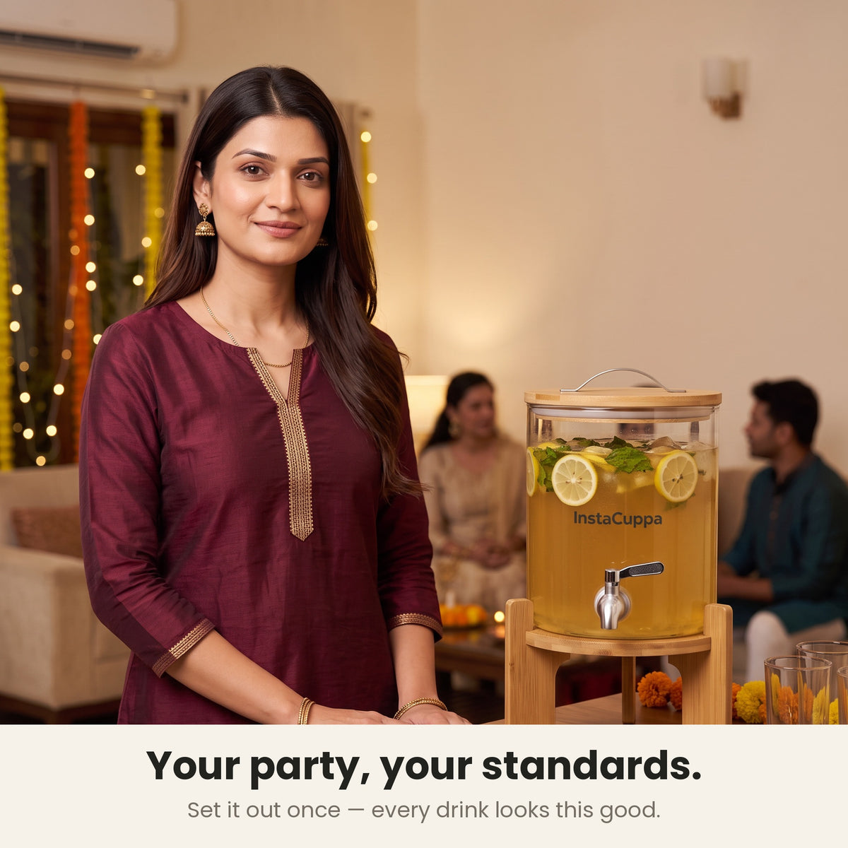 InstaCuppa Glass Water Dispenser 5 Litre — host in a maroon kurta with the dispenser set out for her guests