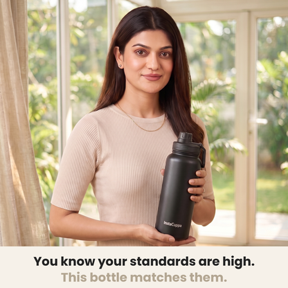 InstaCuppa Insulated Water Bottle 1L (1000 ml) - Black - woman in a cream ribbed knit top holding the bottle in a sunlit room, caption: you know your standards are high, this bottle matches them