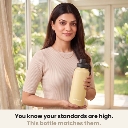 InstaCuppa Insulated Water Bottle 1L (1000 ml) - Yellow - woman in a cream ribbed knit top holding the bottle in a sunlit room, caption: you know your standards are high, this bottle matches them