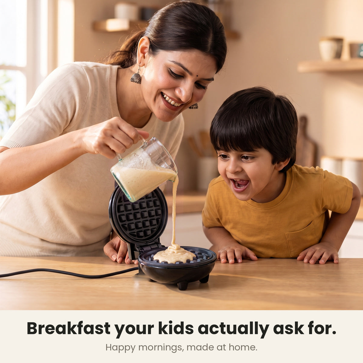 InstaCuppa Mini Waffle Maker 4 inch - Black - breakfast your kids actually ask for: a mother pours batter into the maker while her son watches