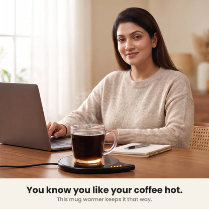 InstaCuppa coffee mug warmer for desk in use at a home office, glass mug hot beside the laptop