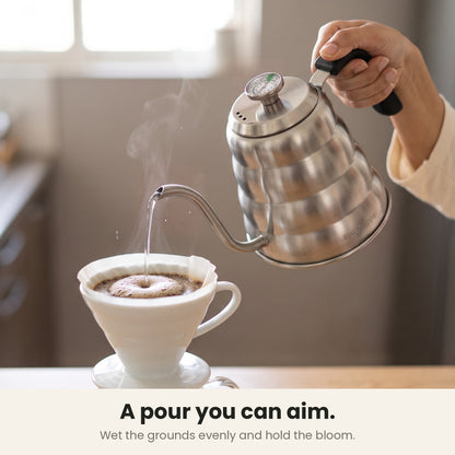 InstaCuppa gooseneck kettle — backlit gooseneck spout pouring a slow, aimed stream over a blooming pour-over coffee bed
